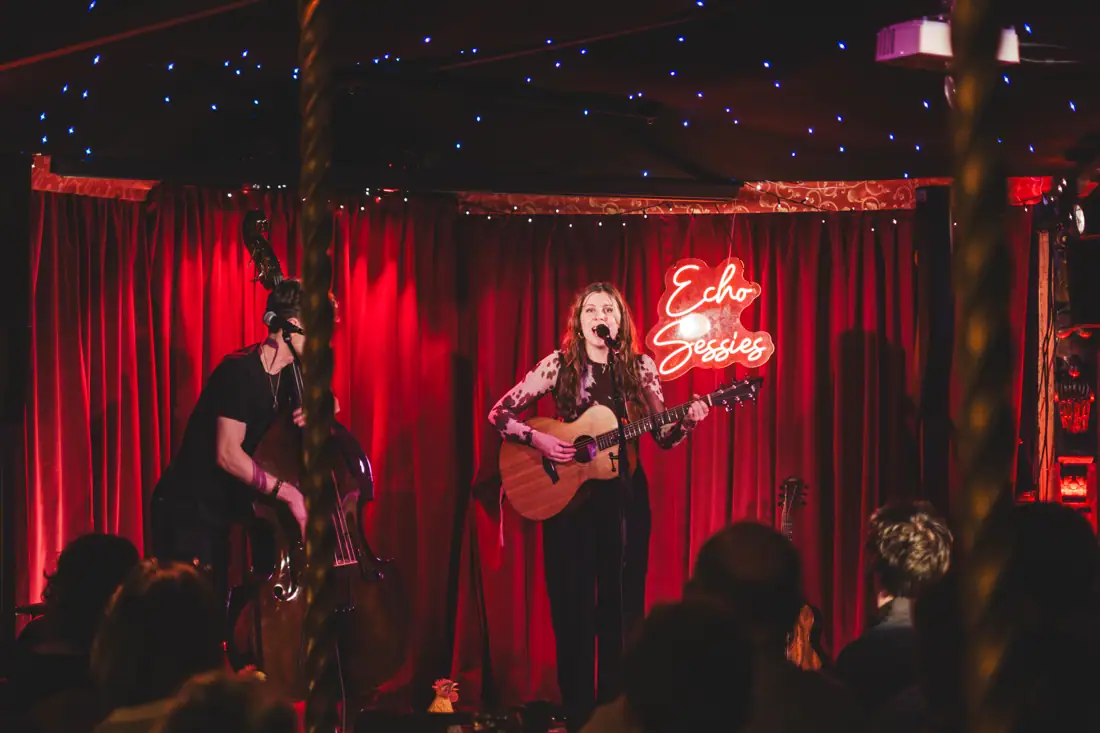 Marcelle met contrabas en gitaar op het podium