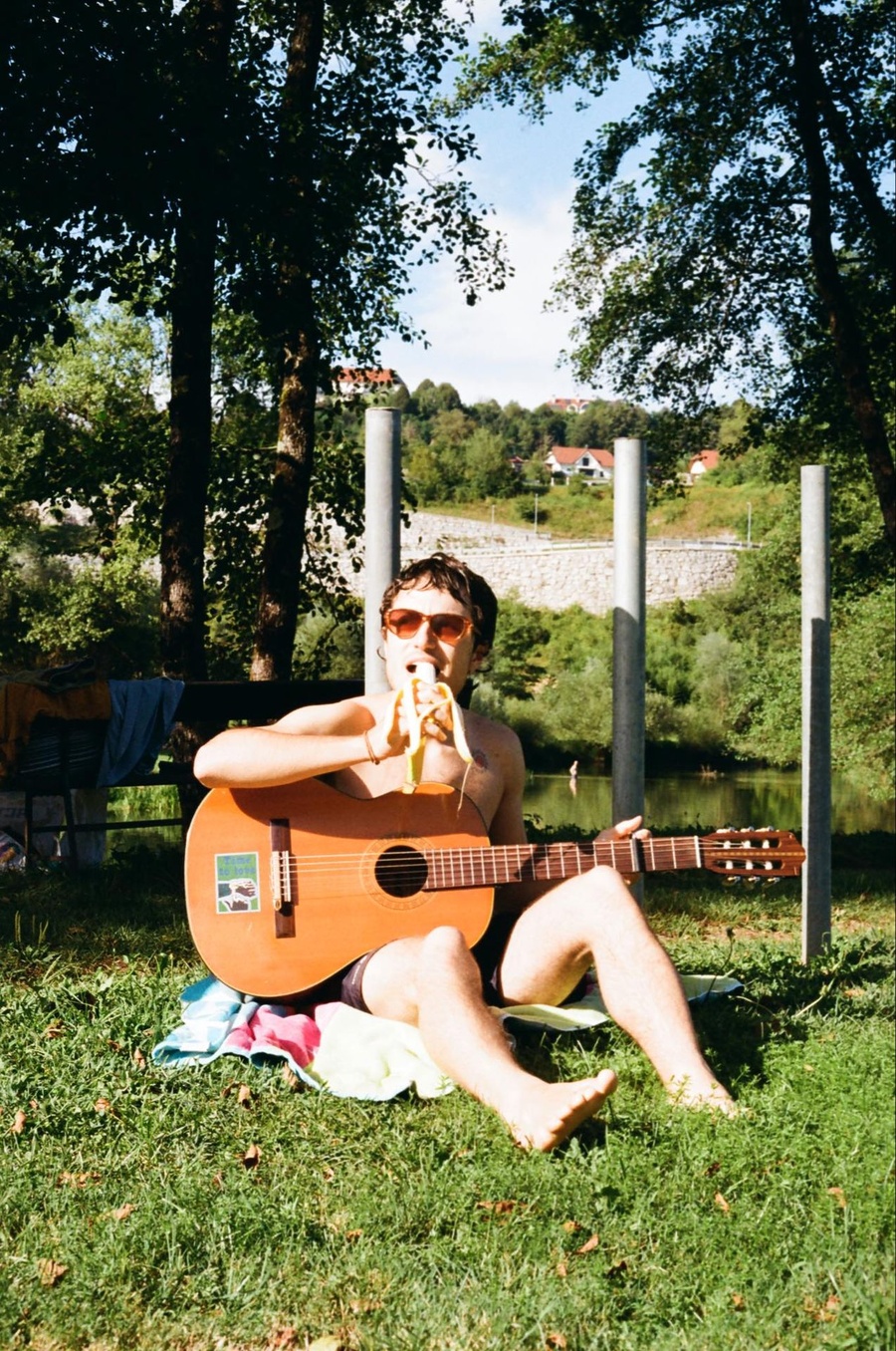 Camilo Donoso met zijn gitaar in het gras, in zwart-wit
